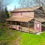 Brown two-story cabin with covered porch